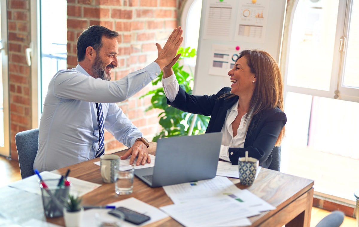 Dos personas celebrando un acuerdo de negocios en una oficina
